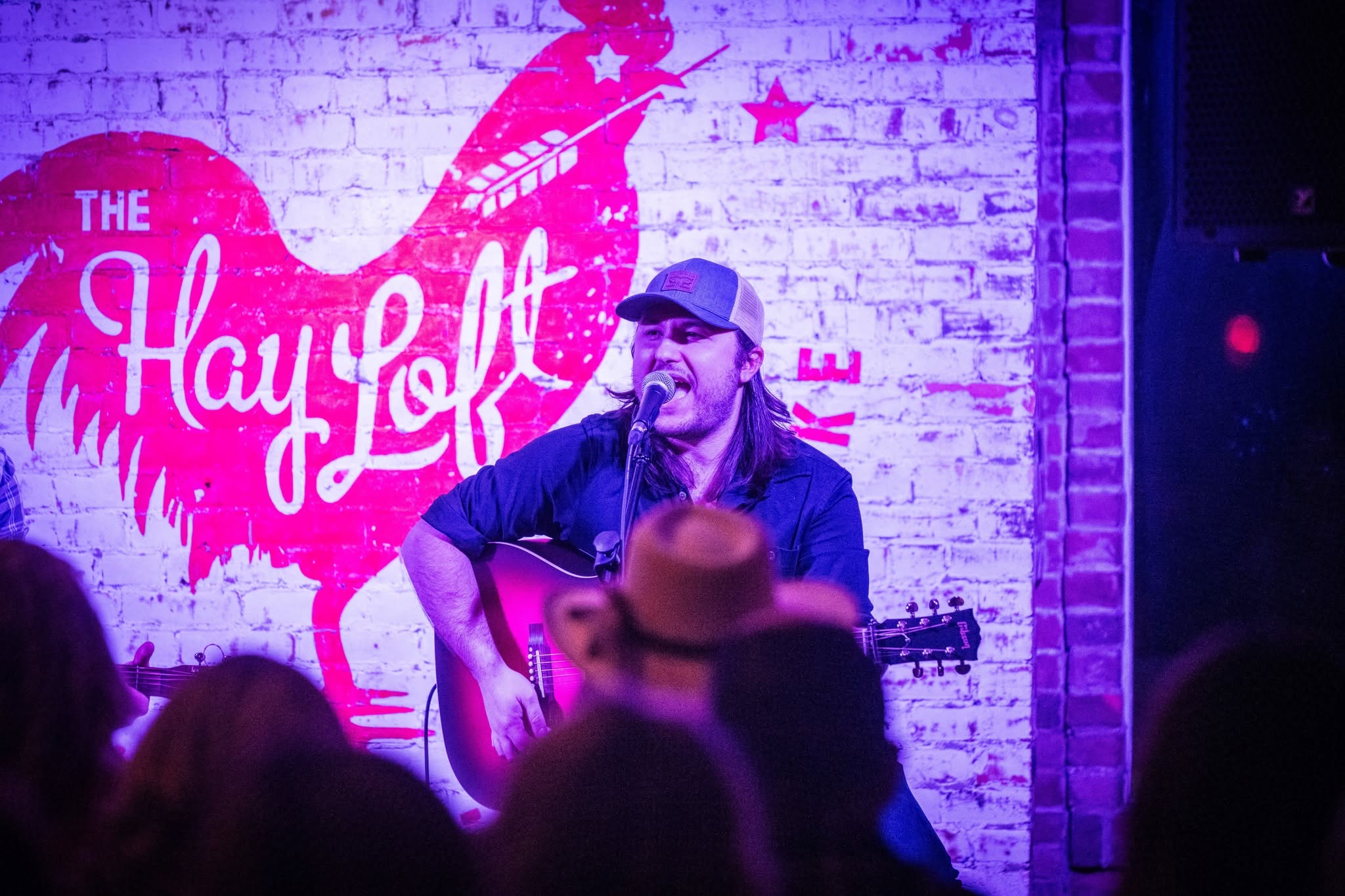 Sean Donley performing with an acoustic guitar at The Hayloft